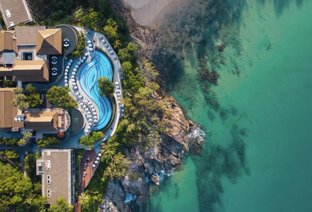 Aerial View of Coastal Resort Featuring Large Curvilinear Pool and Rocky Shoreline at Nai Thon Beach