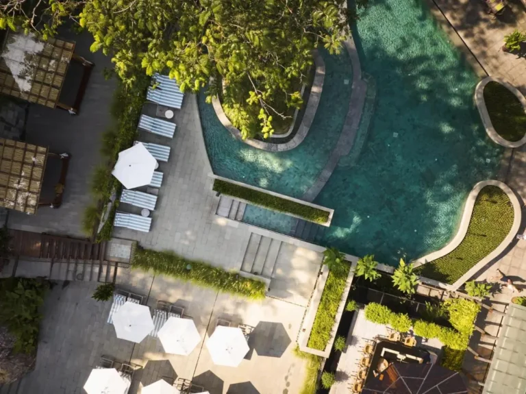Aerial View of Outdoor Pool Area with Lounge Chairs and Shaded Cabanas at Patong Beach