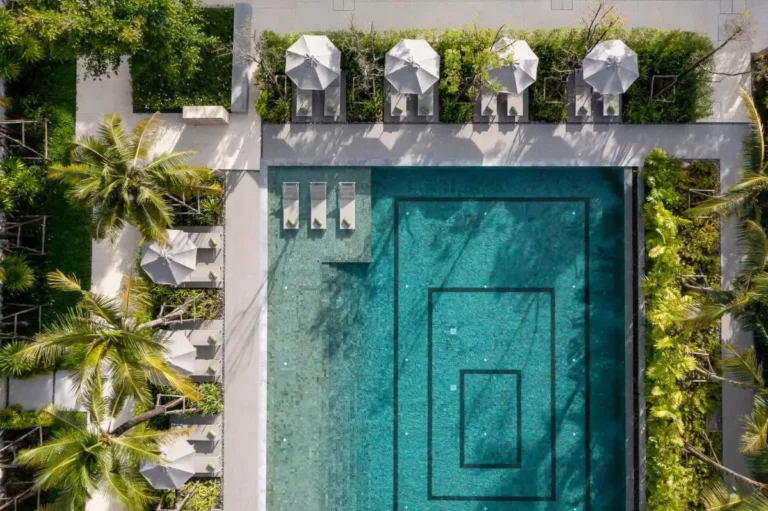 Aerial View of Rectangular Outdoor Swimming Pool with Lounge Chairs and Umbrellas at Mai Khao Beach