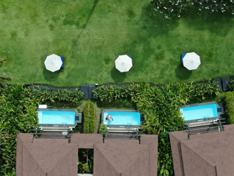 Aerial View of Three Rectangular Pools with Lounge Areas and Tropical Landscaping at Panwa Beach