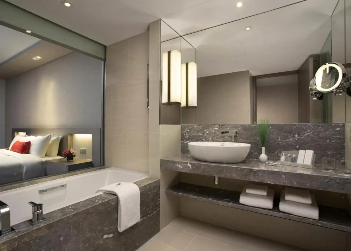 Bathroom with Bathtub and Vanity Featuring Stone Countertop in City Hall Area