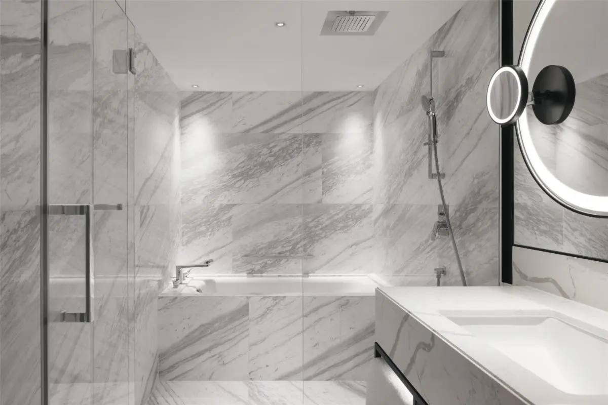 Bathtub and Shower Area with Marble Tiling and Glass Enclosure in Orchard Bathroom