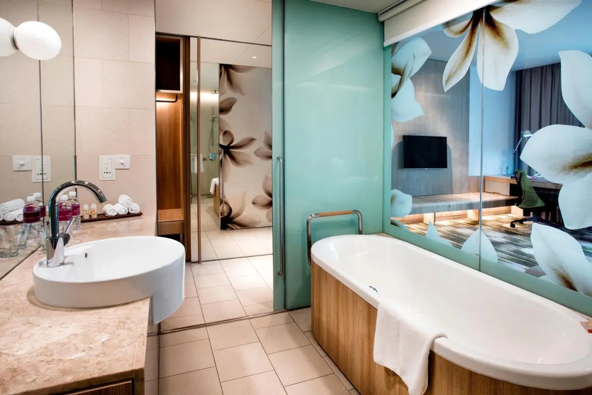 Bathtub and Washbasin Area with Glass Partition and Floral Design in Changi Bathroom