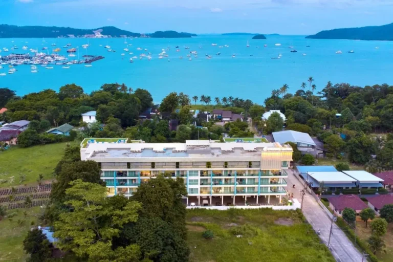 Coastal Multi-Story Building Overlooking Bay with Boats and Tropical Vegetation Near Rawai Beach