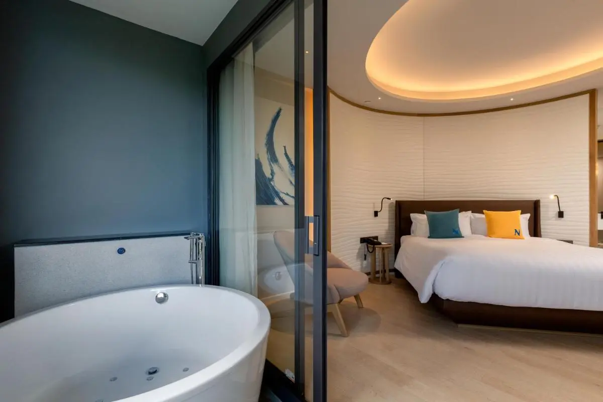 Contemporary Bedroom and Bathroom Space Featuring Freestanding Bathtub and Glass Partition in Patong Beach