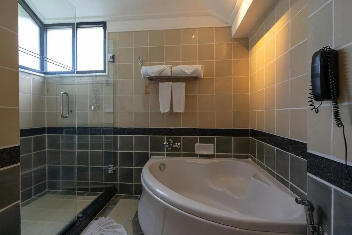 Corner Bathtub and Glass-Enclosed Shower with Tiled Walls in Panwa Beach Bathroom