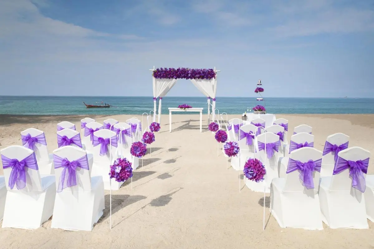 Dusit Thani Laguna Phuket Elegant Beachside Wedding Setup with White Chairs and Purple Floral Decorations at Bang Tao Beach Phuket Province