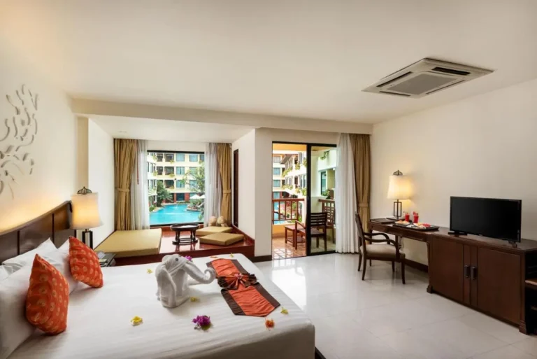Hotel Room with Pool View, Balcony Seating, and Decorative Bed Elements at Patong Beach