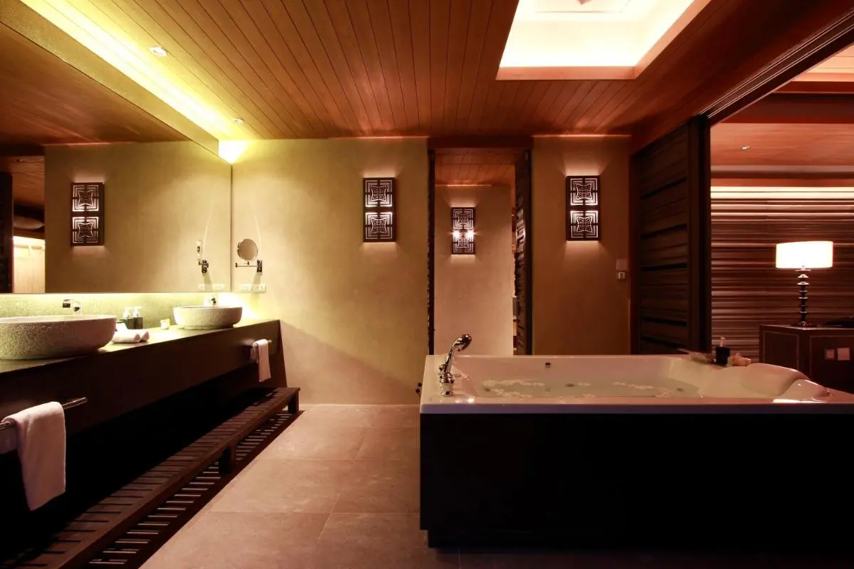 Sri Panwa Phuket Luxury Pool Villa Hotel Indoor Bathroom Featuring Large Bathtub and Dual Stone Vessel Sinks with Warm Lighting