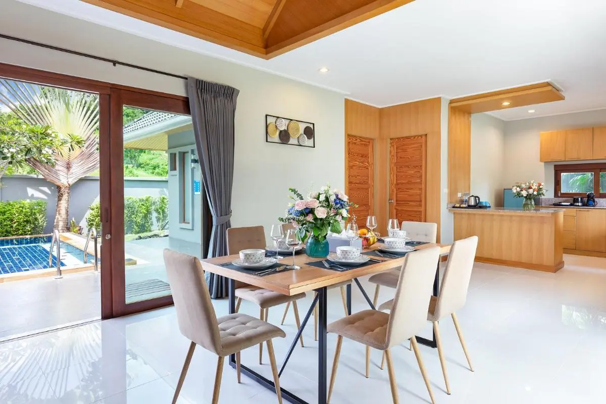 Indoor Dining Area with Outdoor Pool and Kitchen at Rawai Beach Residence