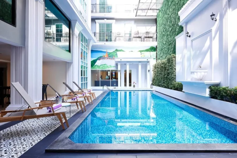 Indoor Rectangular Swimming Pool with Lounge Chairs and Decorative Fountain in Phra Nakhon
