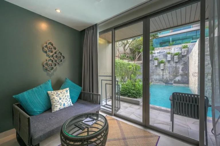Indoor Seating Area with Poolside View and Natural Stone Wall at Patong Beach