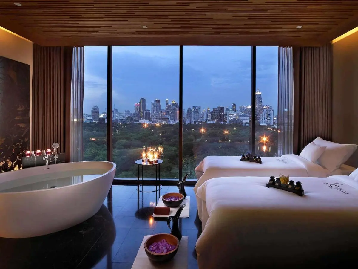 Indoor Spa Room with Massage Tables and Bathtub Overlooking Bangkok Skyline in Bang Rak