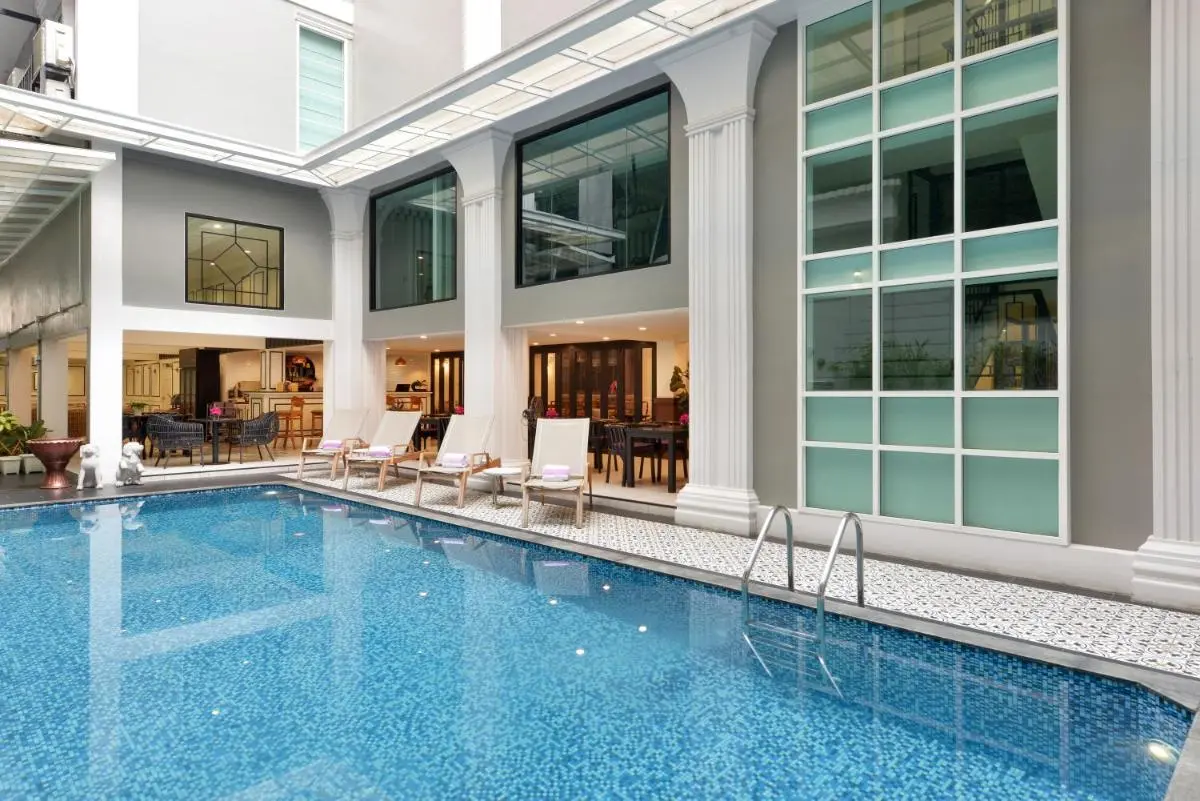 Villa De Pranakorn Indoor Swimming Pool Area with Lounge Chairs and Large Windows in Phra Nakhon Bangkok