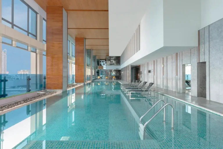 Indoor Swimming Pool Area with Lounge Chairs and Urban Views in Pathumwan Bangkok