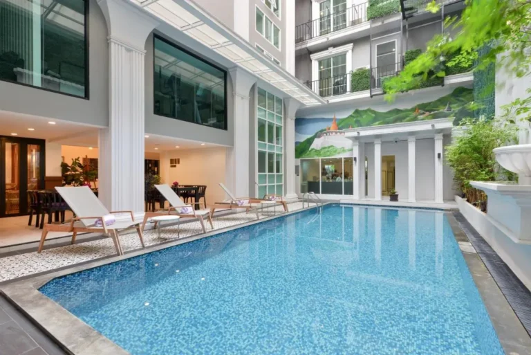 Indoor Swimming Pool Area with Lounge Seating and Decorative Mural in Phra Nakhon