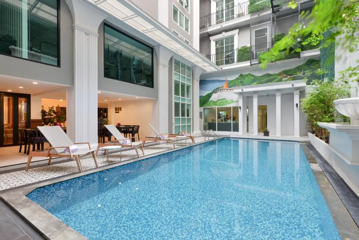 Indoor Swimming Pool Area with Lounge Seating and Decorative Mural in Phra Nakhon