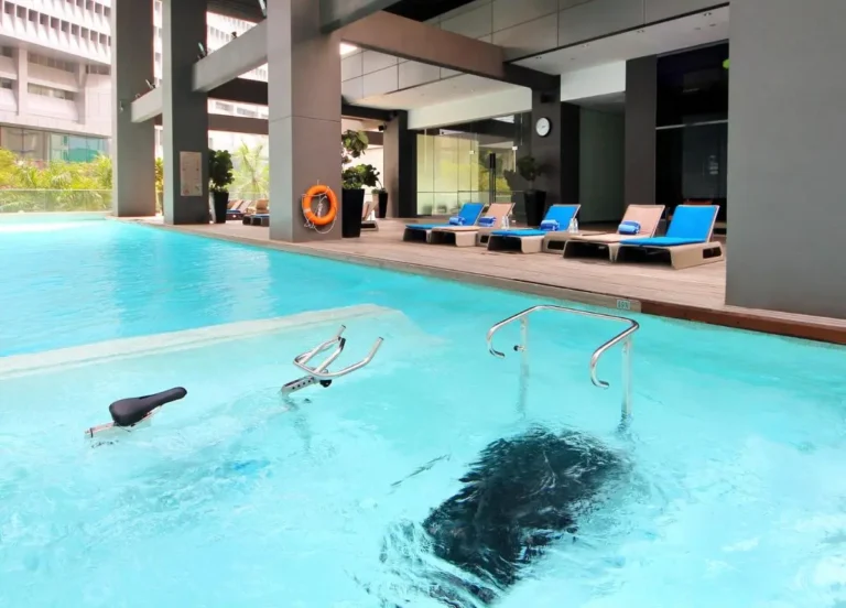 Indoor Swimming Pool with Aquatic Exercise Bike and Lounge Seating in Singapore
