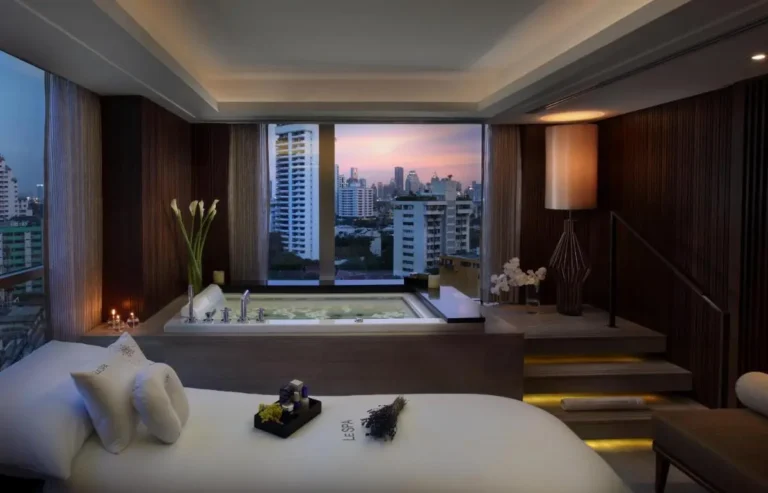Indoor Wellness Room with Whirlpool Bathtub and Massage Table Overlooking Bangkok Skyline in Wattana