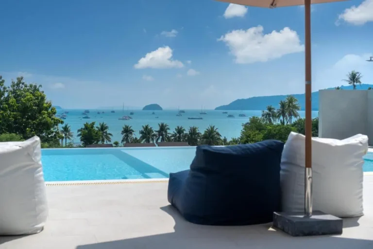 Infinity Pool Overlooking Calm Sea with Sailboats and Palm Trees at Rawai Beach