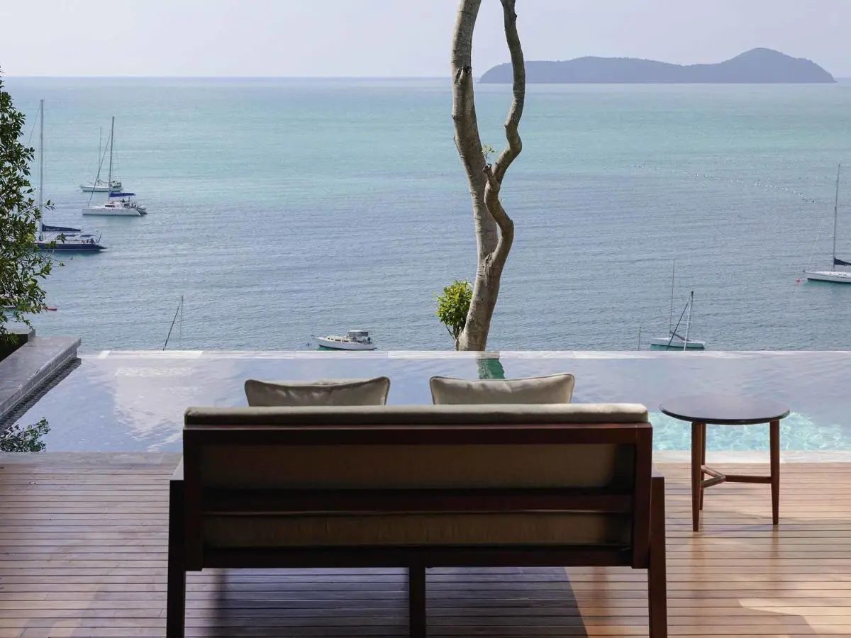 Infinity Pool Overlooking Ocean with Wooden Deck and Secluded Seating at Panwa Beach