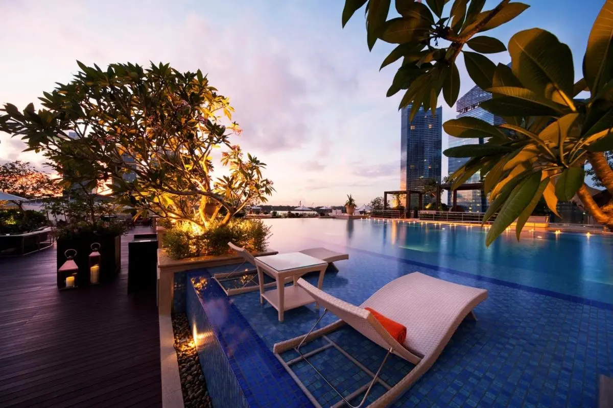 The Fullerton Bay Hotel Singapore Infinity Pool with Lounge Seating and City Views at Marina Bay Rooftop