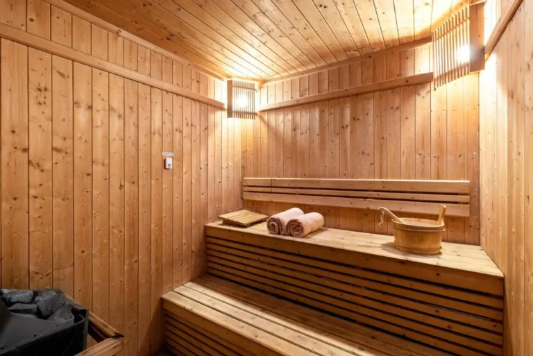 Interior View of Traditional Wooden Sauna Room with Two-Tier Benches and Sauna Stones
