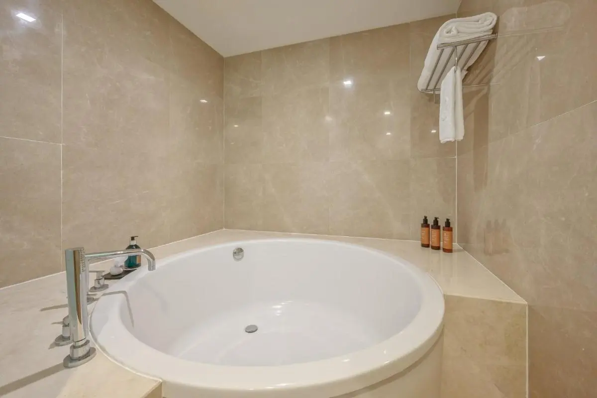 Minimalist Bathroom with Built-In Round Bathtub and Marble Surround in Chatuchak