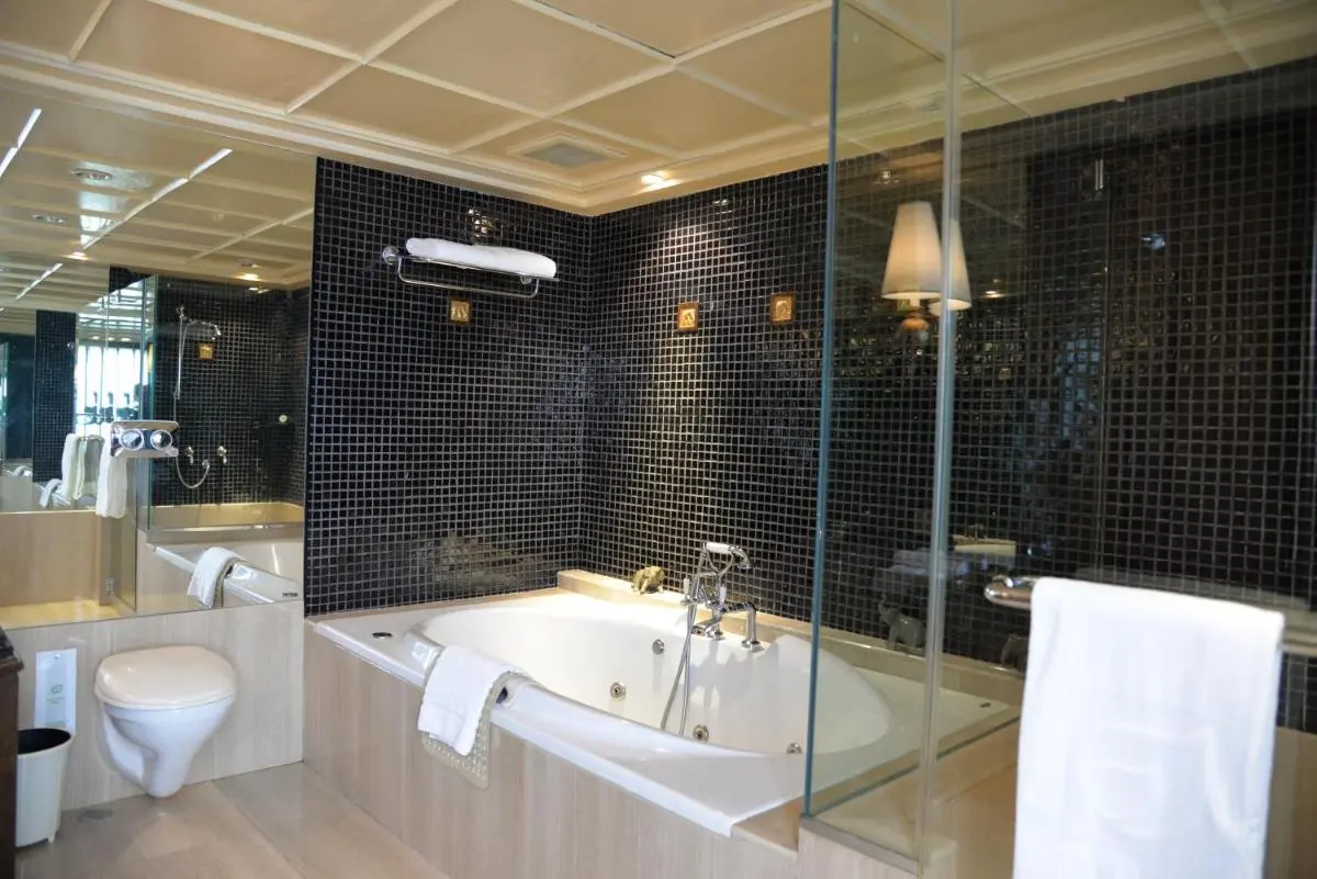Modern Bathroom Design Featuring Built-In Bathtub and Glass Partition in Laksi