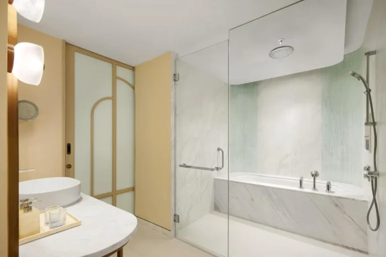 Modern Bathroom Design Featuring Combined Shower and Bathtub with Marble and Green Tile Accents