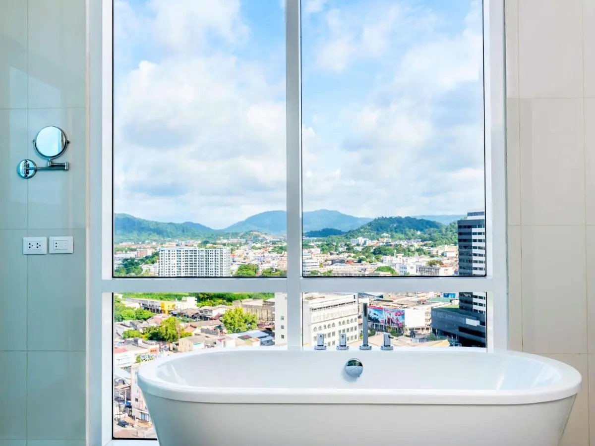 Novotel Phuket City Phokeethra Modern Bathroom with Freestanding Tub and Panoramic Urban Views in Phuket Town