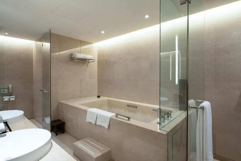 Modern Beige Tiled Bathroom with Built-In Bathtub and Glass Partition in Pathumwan