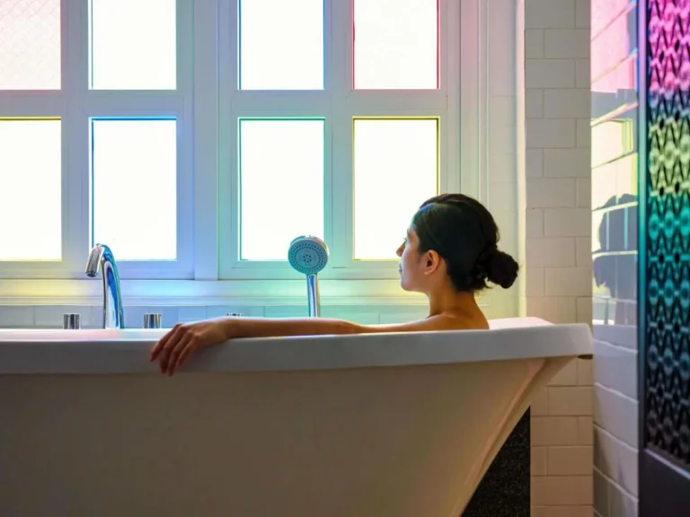 Modern Freestanding Bathtub with Multicolored Window Light in Relaxing Bathroom Setting