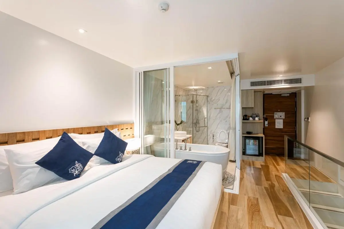 Modern Hotel Room with Glass-Enclosed Bathroom and Freestanding Tub in Chang Phueak Chiang Mai