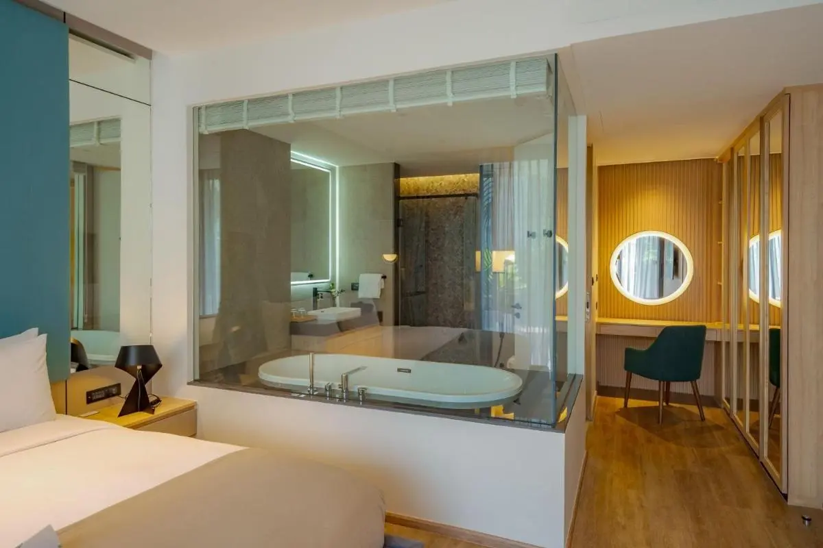 Modern Hotel Suite Featuring Glass-Enclosed Bathroom with Freestanding Tub Near Bang Tao Beach