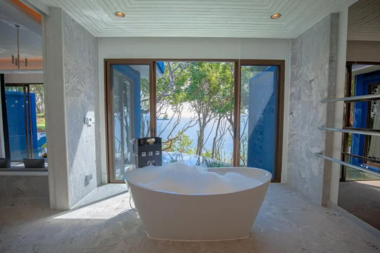 Modern Indoor Bathroom with Freestanding Bathtub and Infinity Pool View at Panwa Beach