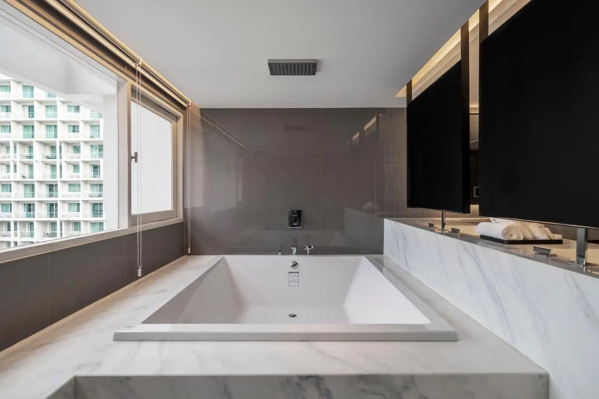 Modern Indoor Bathtub and Shower Area with Marble Surround in Khlong Toei Urban Bathroom