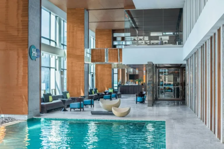 Modern Indoor Pool Area with Seating and Urban Views in Pathumwan Bangkok
