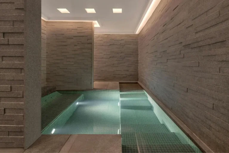 Modern Indoor Pool Area with Stone Walls and Ambient Lighting in Pathumwan Bangkok