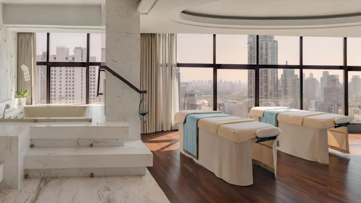 InterContinental Bangkok by IHG Modern Indoor Spa Room with Massage Tables and Soaking Tub Overlooking Pathumwan Skyline