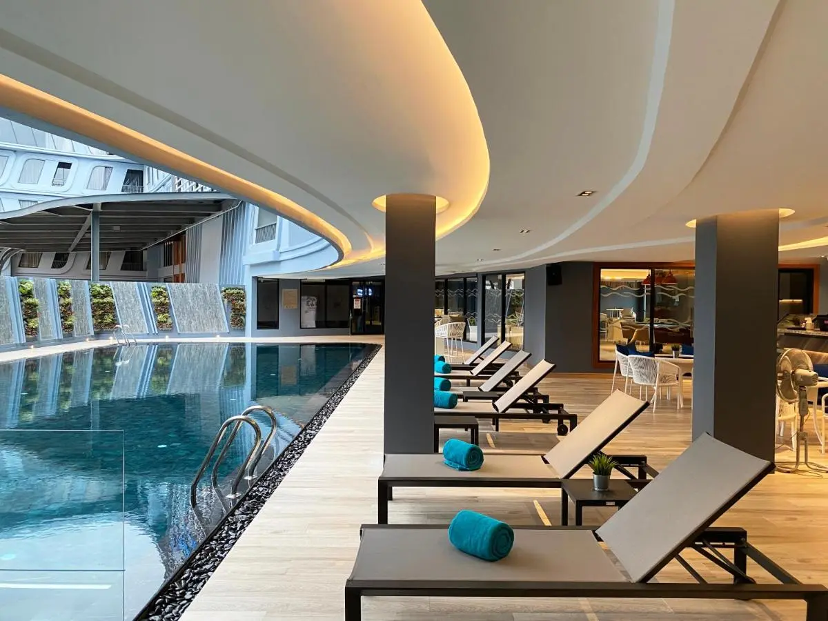 Modern Indoor Swimming Pool Area with Lounge Seating and Water Feature in Phuket Town