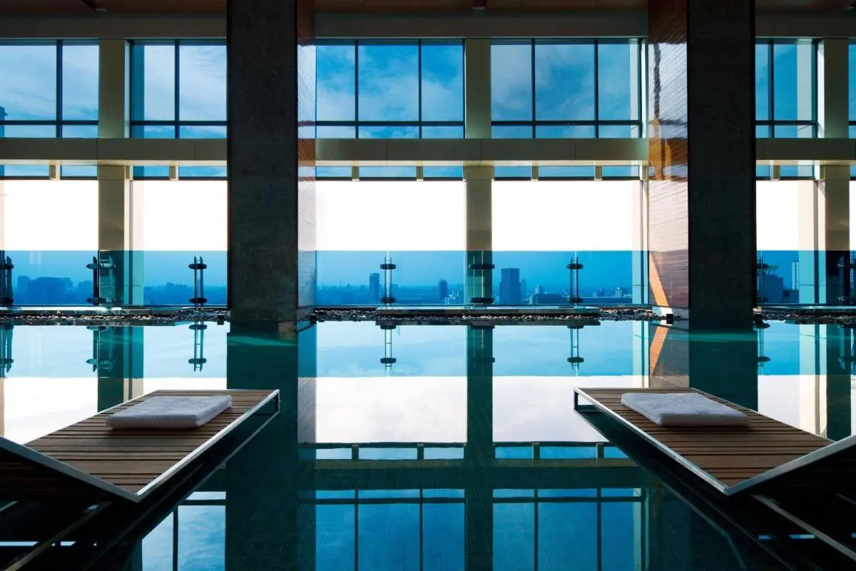 Modern Indoor Swimming Pool with City Views and Lounge Seating in Pathumwan Bangkok
