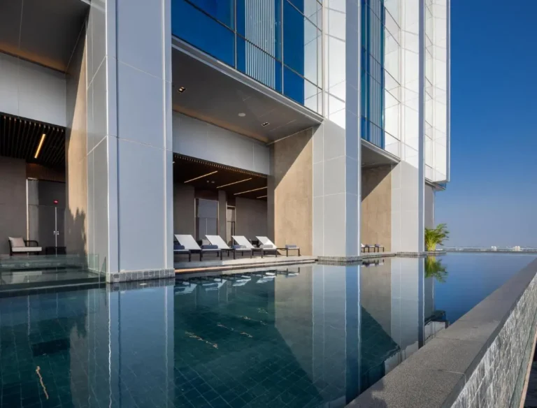 Modern Infinity Pool with Lounge Area and Urban Views in Ratchathewi Bangkok