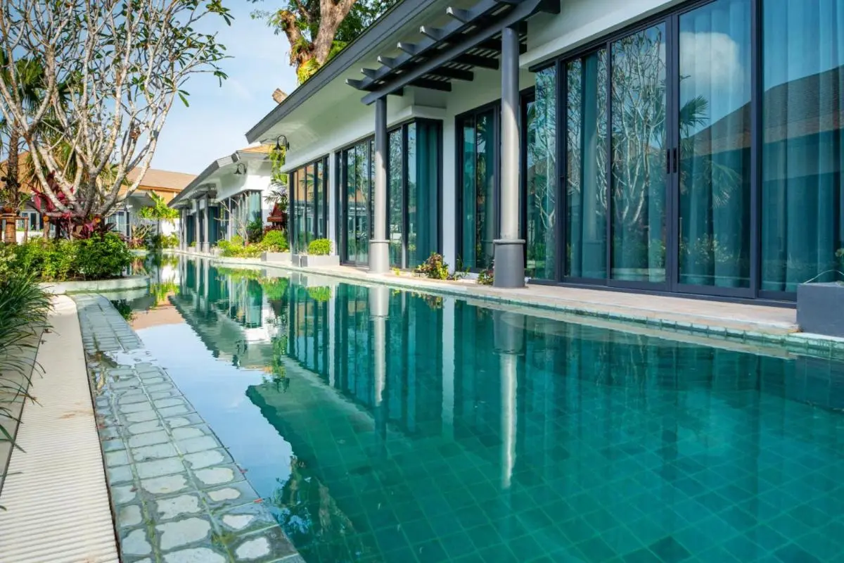 Modern Narrow Swimming Pool with Adjacent Single-Story Buildings in Chalong