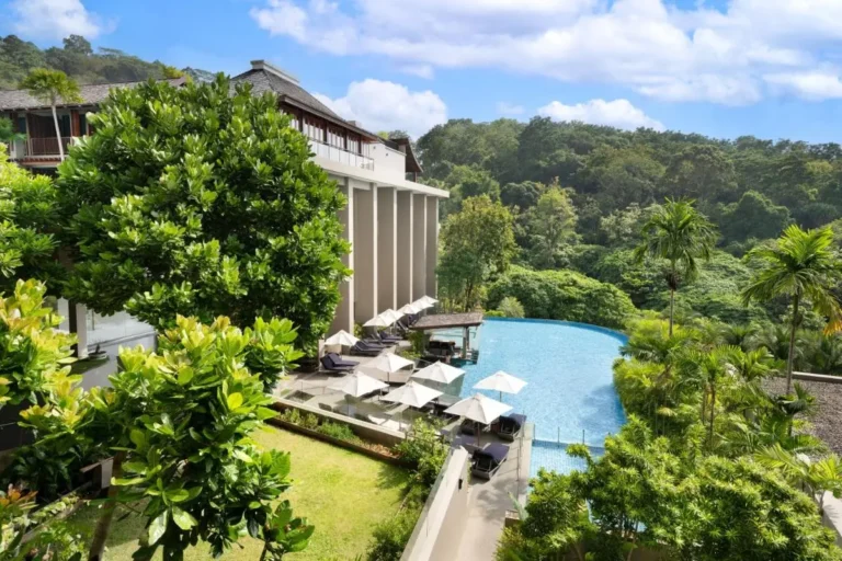 Modern Outdoor Infinity Pool with Lounge Area and Glass Railings at Patong Beach