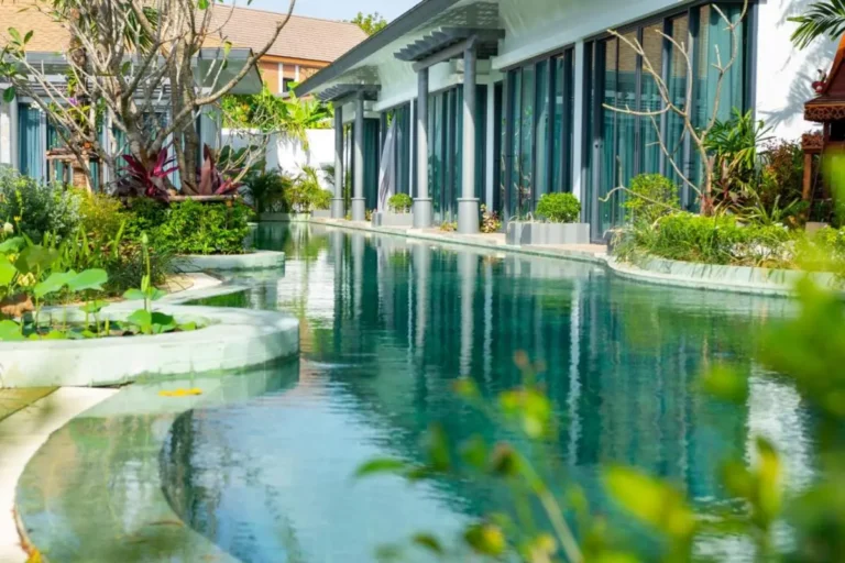 Modern Outdoor Lap Pool with Curved Design and Lush Landscaping in Chalong