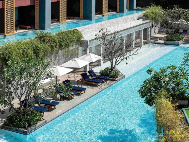 Modern Outdoor Pool Area with Cascading Water Feature and Lounge Seating at Karon Beach