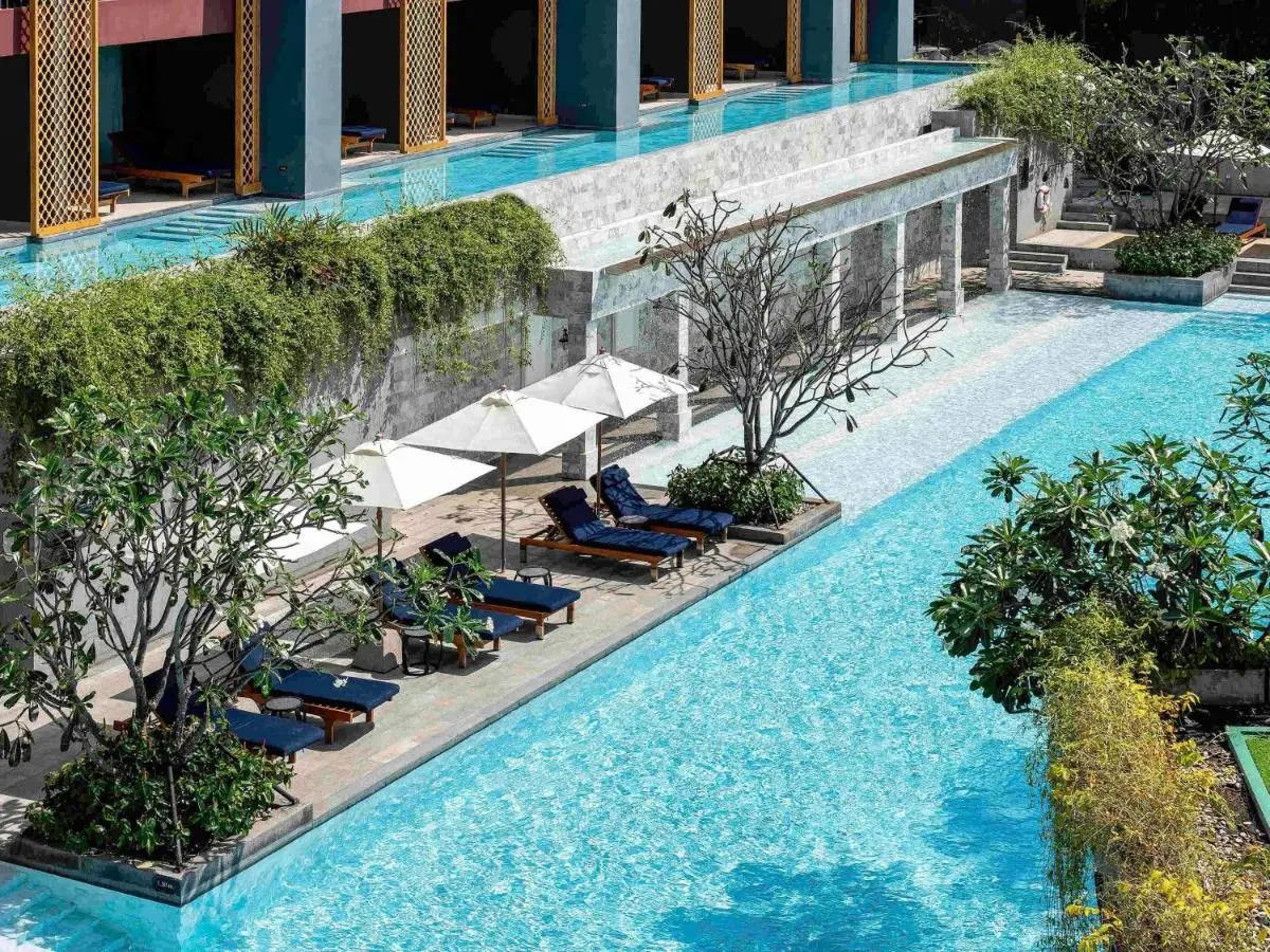 Modern Outdoor Pool Area with Cascading Water Feature and Lounge Seating at Karon Beach