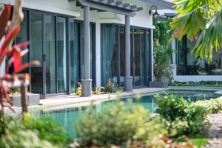 Modern Outdoor Pool Area with Glass Doors and Pergola Overhang in Chalong