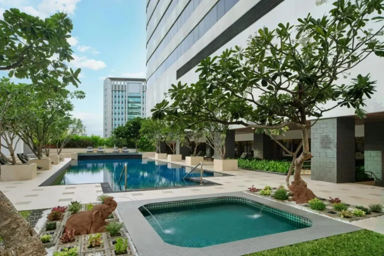 Modern Outdoor Pool Area with Jacuzzi and Lounge in Khlong Toei Urban Setting